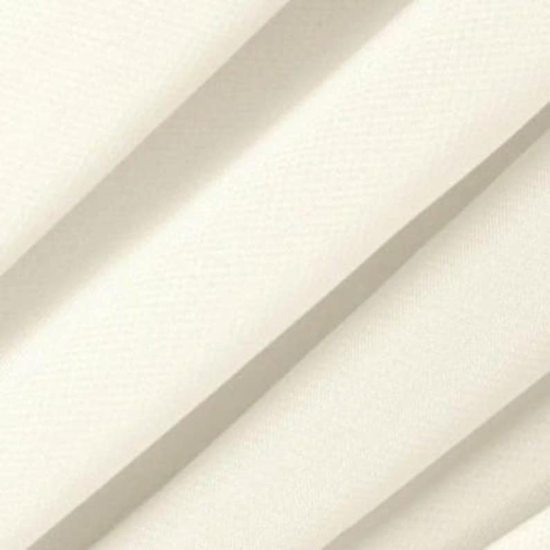 Puede incluir: Primer plano de una tela lisa de color blanco roto con un brillo sutil. La tela est&aacute; doblada de forma que crea l&iacute;neas diagonales.