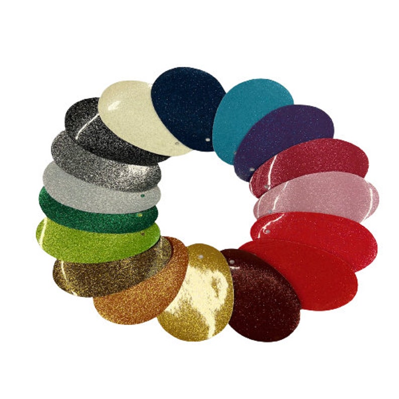 May include: A collection of 14 oval-shaped glitter samples in various colors, including gold, silver, red, green, blue, and purple. The samples are arranged in a circle, with the edges overlapping.