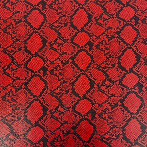 May include: A vibrant red and black snakeskin pattern featuring a repeating diamond-shaped scale texture. The design consists of bold red scales outlined by thin black lines, creating a high-contrast, reptilian-inspired surface.