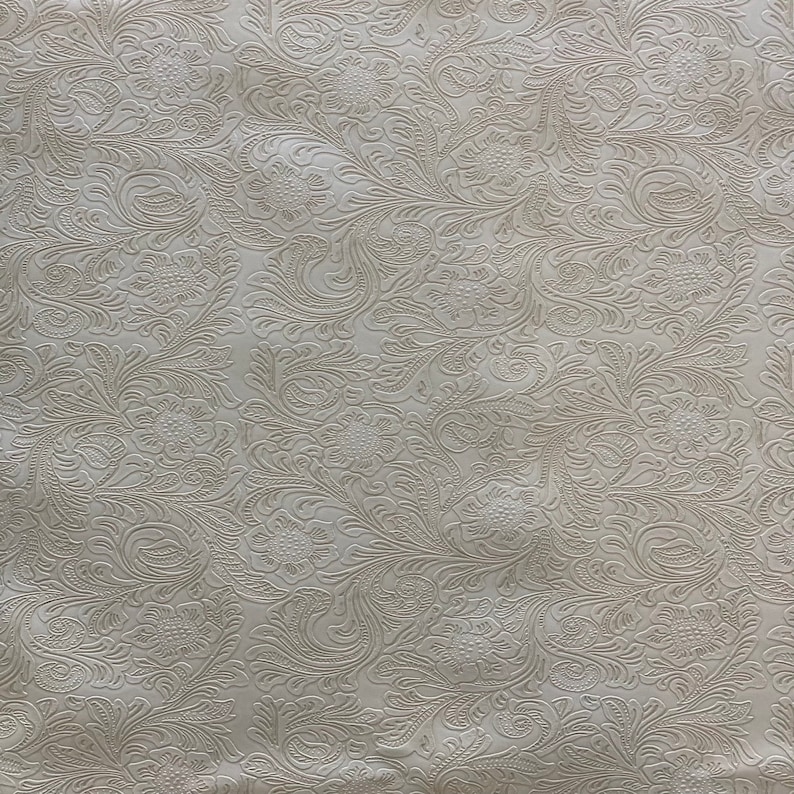 May include: White fabric with an embossed floral pattern. The pattern features intricate swirls and leaves.