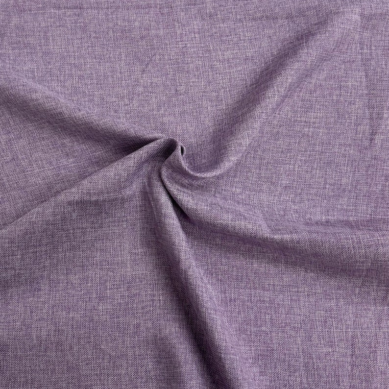 May include: Close-up of a textured, purple fabric with a subtle sheen. The fabric is folded and draped, showcasing its soft and drapey texture.