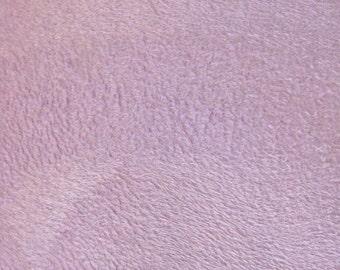 May include: A close-up of a soft, plush, light purple fabric with a textured surface.