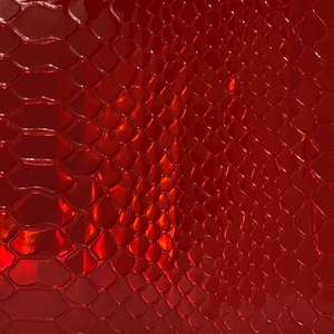 May include: A vibrant red material featuring a glossy, reflective finish with a repeating embossed scale pattern that mimics the texture of snake skin. The surface displays deep crimson tones and highlights created by light reflection.