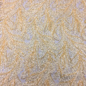 May include: Gold and ivory sequined fabric with a delicate, feathery pattern. The sequins are arranged in a flowing, cascading design.