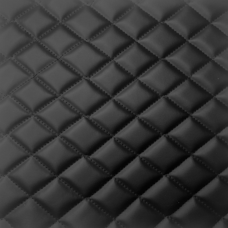 以下が含まれることがあります： 黒色のキルティングレザー素材のクローズアップ。均等に配置されたひし形のステッチパターンで、テクスチャード加工された表面を作り出しています。革は滑らかでわずかな光沢があり、ステッチが施されています。