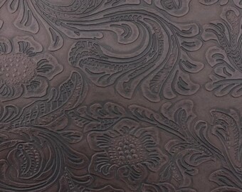 May include: A dark brown surface featuring a deeply embossed floral pattern with intricate swirling leaves and petals. The design is pressed into the material, creating a textured, monochromatic look with raised lines and recessed areas.