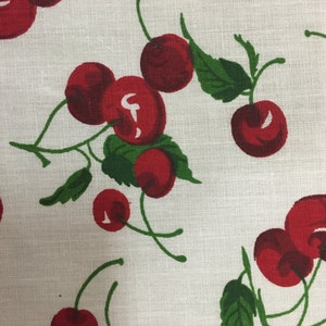 May include: White fabric with a repeating pattern of red cherries and green leaves.