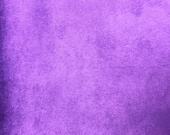 May include: A vibrant purple fabric surface with a soft, textured, and slightly fuzzy appearance. The material displays subtle variations in tone, creating a rich, deep violet color profile across the entire visible area of the textile.