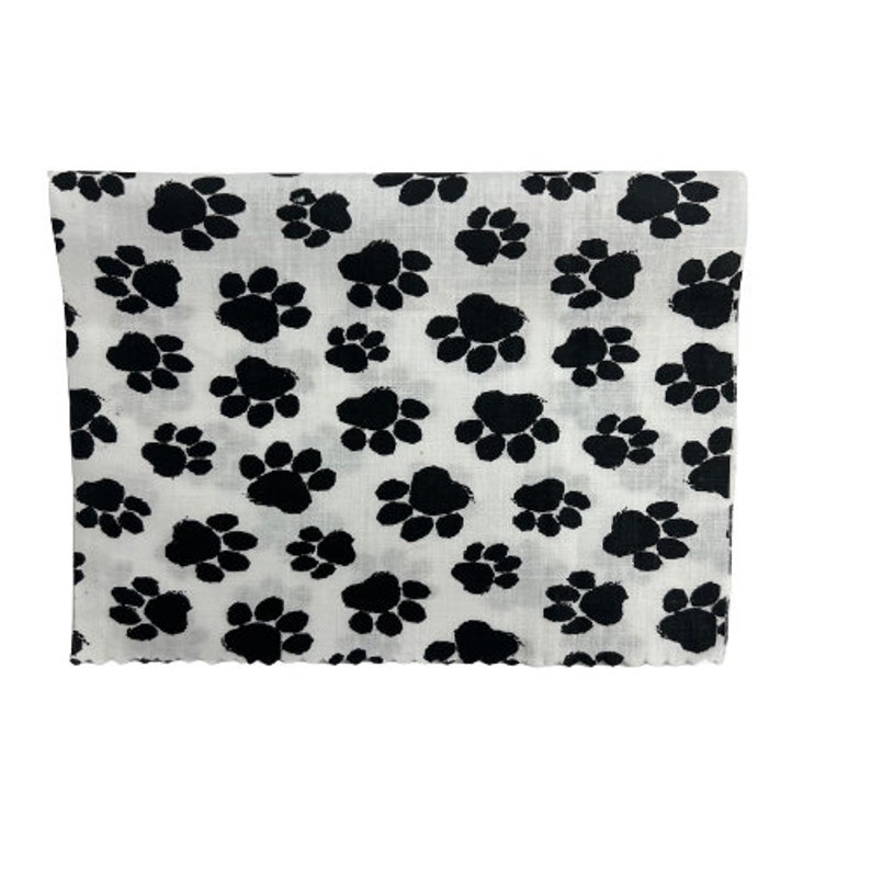 May include: White fabric with a black paw print pattern.
