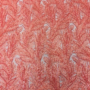 May include: Coral pink fabric with a delicate floral pattern. The fabric is covered in sequins and beads, creating a shimmering effect.