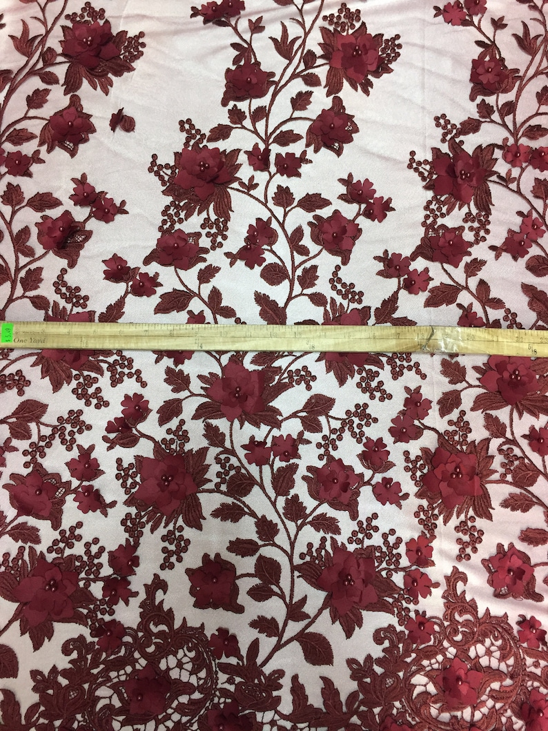Puede incluir: Tela de encaje floral burdeos con flores 3D y detalles de perlas. La tela tiene un fondo de malla delicado.