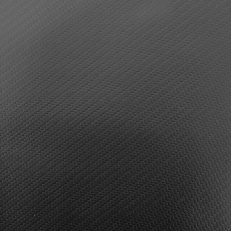 May include: A close-up of a black textured surface with a subtle diamond pattern.