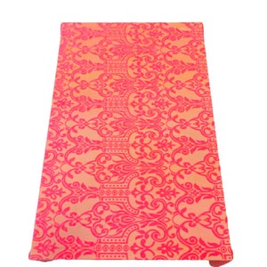 May include: A pink and orange fabric with a damask pattern. The fabric has a subtle sheen and a soft texture.