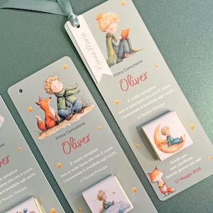 Op de afbeelding: Lichtgroene bladwijzers met illustraties van een jongen en een vos, met de tekst "Prima Comunione Oliver". De bladwijzers hebben een lint en steraccenten en bevatten tekst uit "Il Piccolo Principe".