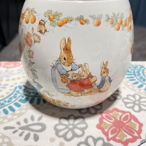 vintage ceramic vase or planter featuring illustrations of Peter Rabbit and his family, originally produced by Teleflora in 1996.