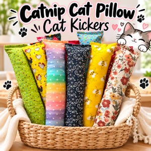 May include: A collection of rectangular catnip cat pillows in a woven basket. The fabric patterns include green with dots, yellow with chickens, rainbow stripes with dots, navy blue with paisley, yellow with bees, and a floral print with red flowers.