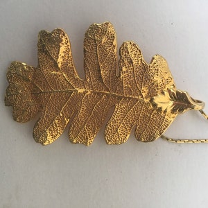 Gold colored metal oak leaf necklace with chain