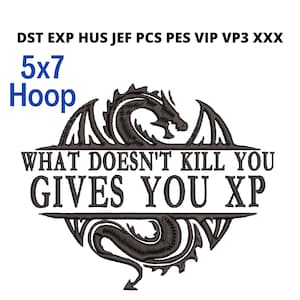 May include: An embroidered design featuring a dragon and the text "WHAT DOESN'T KILL YOU GIVES YOU XP". The design is framed by a decorative border and includes the text "5x7 Hoop".