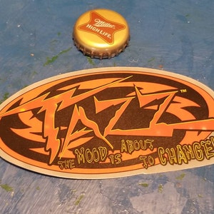 May include: Orange and black sticker with the text "The mood is about to change!" and a stylized logo with the word "FAZE" in a lightning bolt design.