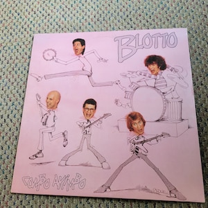 Könnte beinhalten: Rosa Albumcover mit Cartoon-Illustrationen einer Band. Die Bandmitglieder sind mit übertriebenen Merkmalen gezeichnet und spielen verschiedene Instrumente. Der Albumtitel "Blotto" ist in einer stilisierten Schriftart, und das Album trägt den Titel "Combo Akimbo".