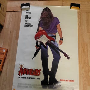 May include: Movie poster for "Airheads" featuring a person holding a red and white electric guitar. The poster has the text "The Music. The Legend. The Hostage Situation." and "Coming this Summer."