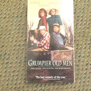 May include: A VHS tape for the movie "Grumpier Old Men" featuring Jack Lemmon, Walter Matthau, and Ann-Margret. The cover shows the cast in a boat, with the title and tagline "Still Yelling. Still Fighting. Still Ready for Love."