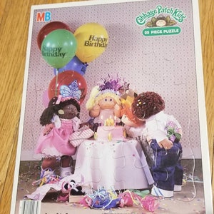 May include: A 25-piece puzzle featuring Cabbage Patch Kids celebrating a birthday with balloons, cake, and confetti. The puzzle is recommended for ages 3 to 7.