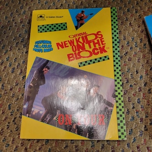 May include: A vintage "New Kids on the Block" Golden Book. The cover is yellow with the band's name in red and blue. It features a photo of the band and the text "Featuring Full Color Photo Pages."