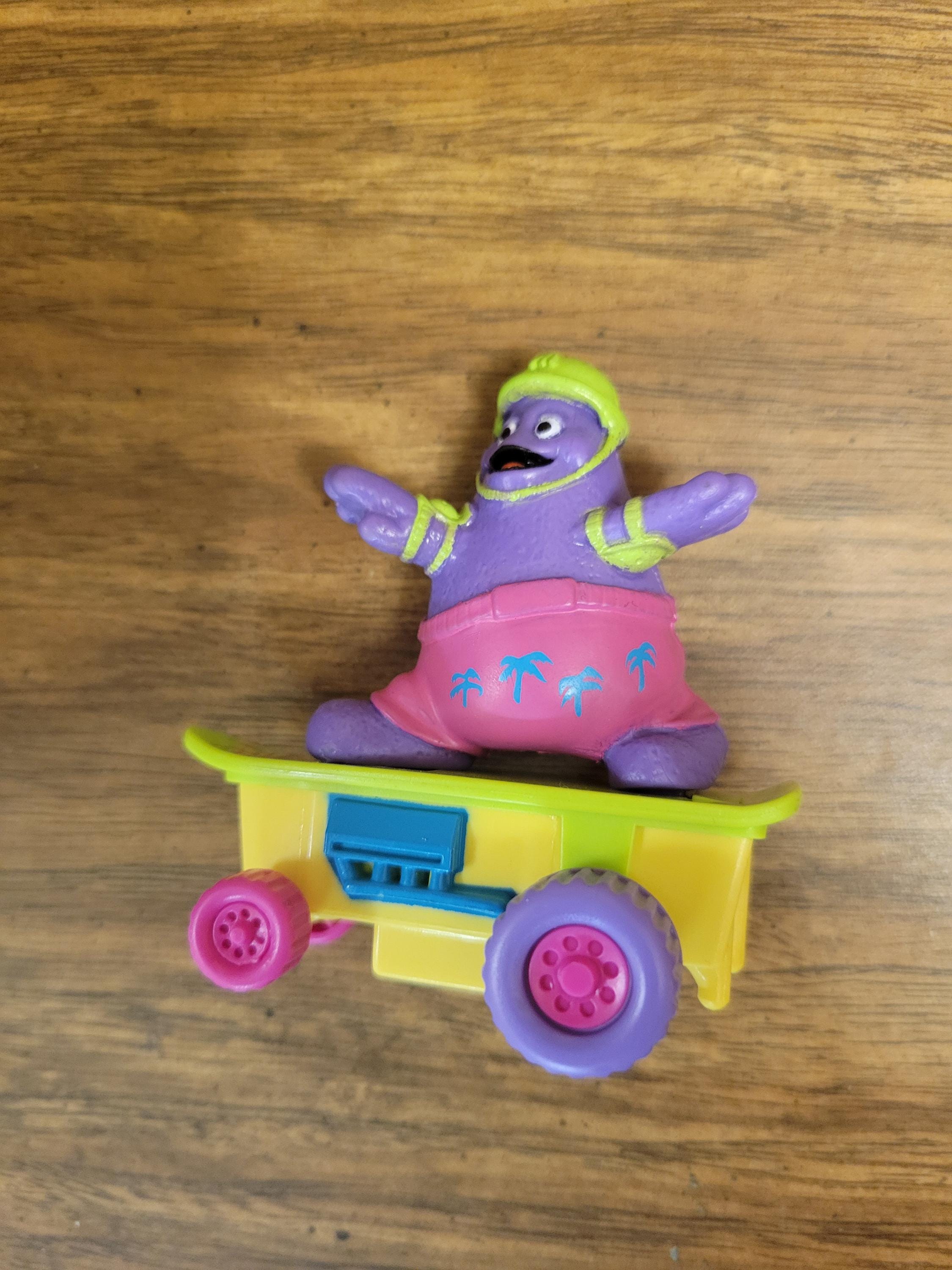 Mcdonalds Grimace on Skateboard Pink Shorts Green Helmet Happy