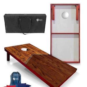 May include: A regulation size cornhole set with a red and brown wooden board, a black carrying bag, and red and blue bean bags. The board has a white circle in the center and a red trim. The bag has the text "Tailgating Pros" printed on it.