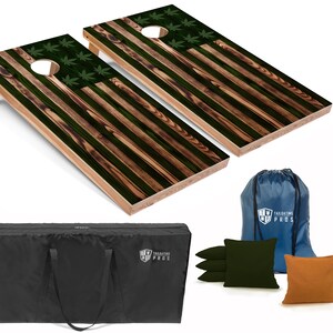 May include: A set of two wooden cornhole boards with an American flag design featuring green marijuana leaves. The boards come with a carrying case, bean bags, and a drawstring bag. The bag has the text "Tailgating Pros" printed on it.