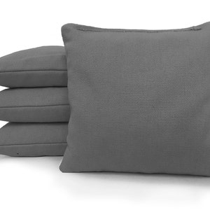 May include: Four gray canvas bean bags stacked on top of each other. The bean bags are made of a soft, durable fabric and are perfect for playing cornhole or other games.