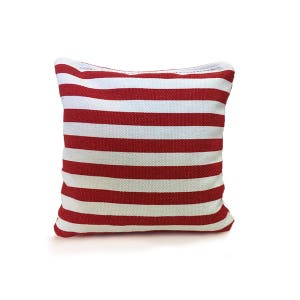 May include: Red and white striped canvas bean bag. The bean bag is square shaped and has a zipper closure.