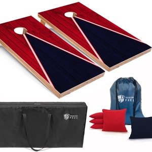 May include: Two red and blue wooden cornhole boards with a white triangle design. The boards are set up for a game. The set includes a black carrying case, a blue drawstring bag, and red and blue bean bags.