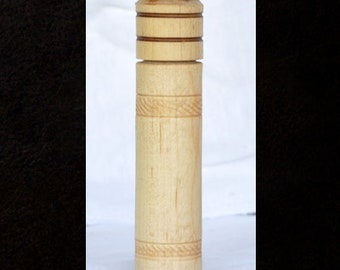 May include: A wooden spice jar with a natural finish and a carved design around the top and bottom.
