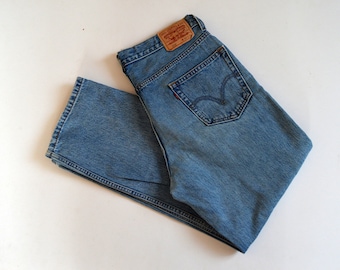 May include: A pair of light blue denim jeans with a brown leather patch that says "Levi's" on the back. The jeans have a classic five-pocket style.