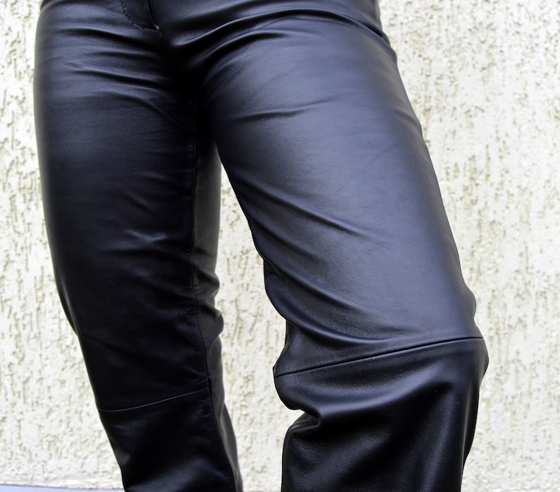 May include: Black leather pants with a smooth, shiny finish. The pants have a straight leg and a classic fit.