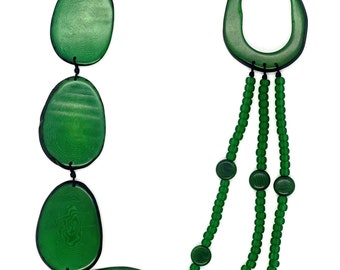 Puede incluir: Un collar de declaración verde con cuentas grandes ovaladas y redondas. El collar está hecho de madera y tiene un aspecto natural y orgánico.