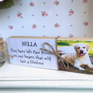 May include: Wooden memorial plaque with a photo of a dog and the text "Bella You have left Paw Prints on our hearts that will last a lifetime."