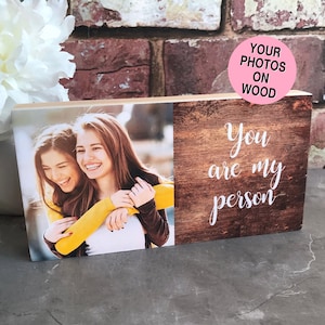 May include: Wooden block with a photo of two women hugging and the text "You are my person" on a woodgrain background.