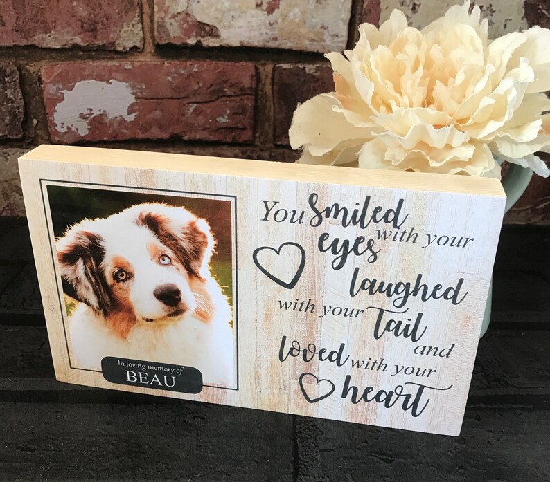 K&ouml;nnte beinhalten: Eine Holz-Gedenktafel mit einem Foto eines Hundes und dem Text "In liebevoller Erinnerung an BEAU Du hast mit deinen Augen gel&auml;chelt, mit deinem Schwanz gelacht und mit deinem Herzen geliebt".
