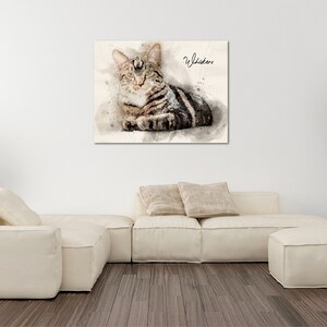 May include: Watercolor painting of a tabby cat with green eyes, lying down and looking to the right. The cat's name, "Whistler", is written in cursive in the top right corner of the painting.