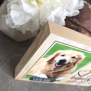 Puede incluir: Bloque de madera conmemorativo con una foto de un perro golden retriever. El texto en el bloque dice "En memoria cari&ntilde;osa de Goldie".