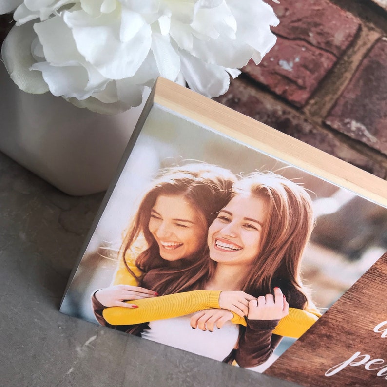 May include: A wooden photo block with a picture of two women smiling and hugging. The text "a piece of my heart" is written on the wood.