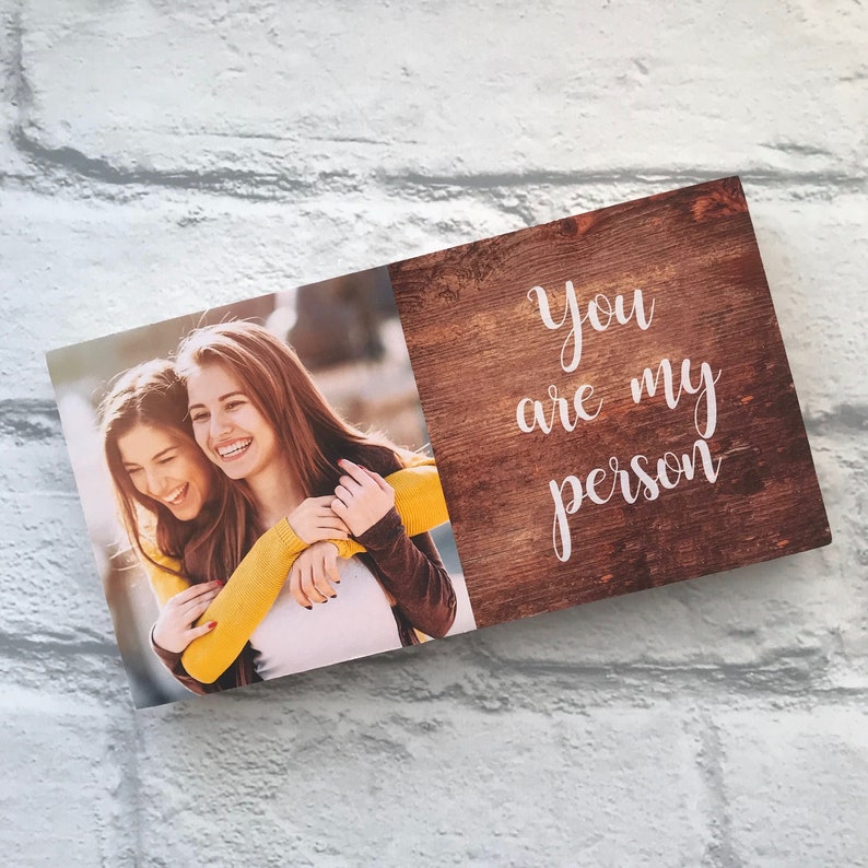 May include: A wooden sign with a photo of two women hugging. The sign says "You are my person" in white script.