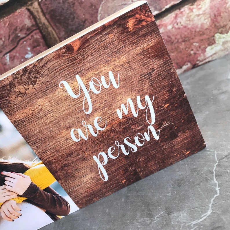 May include: A wooden sign with a rustic brown finish and white text that reads "You are my person".