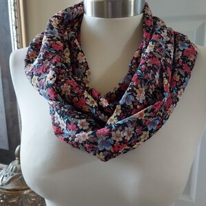 May include: A black floral infinity scarf with a variety of colorful flowers, including pink, red, blue, and yellow.