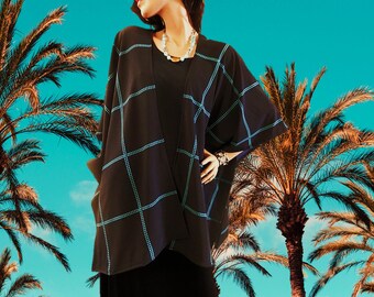 May include: A black and blue checkered kimono with a long sleeve and a wide, open front. The kimono is worn over a black top and black pants.