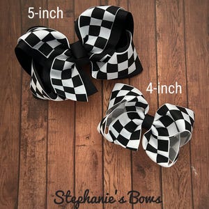K&ouml;nnte beinhalten: Zwei schwarz-wei&szlig;e karierte Haarb&auml;nder, eines 5 Zoll und eines 4 Zoll gro&szlig;. Stephanie's Bows.