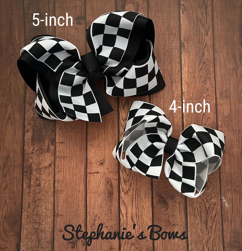 K&ouml;nnte beinhalten: Zwei schwarz-wei&szlig;e karierte Haarb&auml;nder, eines 5 Zoll und eines 4 Zoll gro&szlig;. Stephanie's Bows.